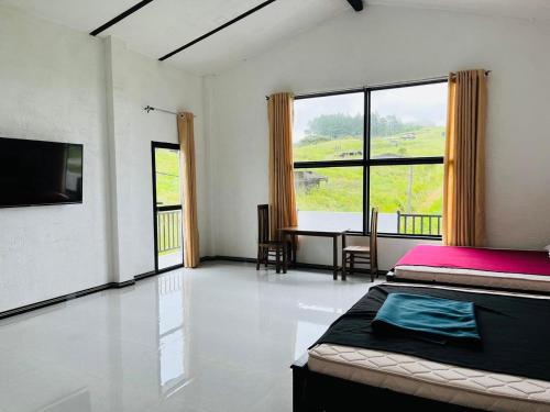 a bedroom with a bed and a desk and a large window at N4 Rest Hanthana in Etulgama