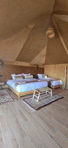 a bedroom with two beds in a tent at Roaming Desert Luxury Camp in Lac Yasmins
