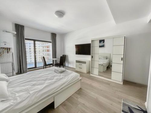 a bedroom with a bed and a desk and a television at Black Sea Booking - Helsinki in Năvodari