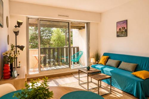 a living room with a blue couch and a window at Pool 3 Balconies & Parking in La Baule