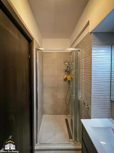 a shower with a glass door in a bathroom at Black Sea Booking - Helsinki in Năvodari