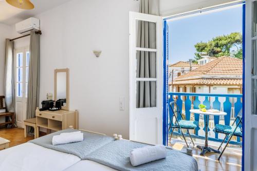 a bedroom with a bed and a view of a balcony at Adonis Rooms in Skopelos Town
