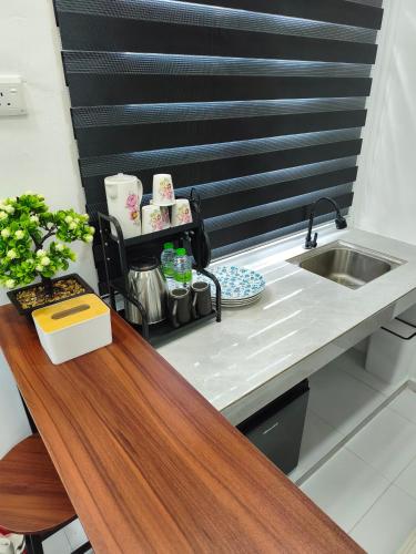 a kitchen with a sink and a wooden counter top at The Kobe House 2 in Kuala Berang