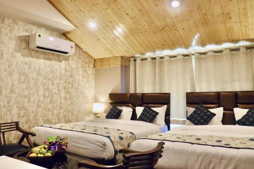a hotel room with two beds and a table with fruit at SkyRidges in Srinagar