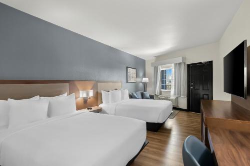 a hotel room with two beds and a flat screen tv at Hyatt Select Galveston Beachfront in Galveston
