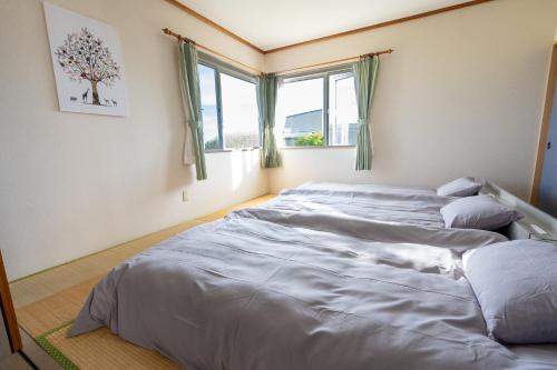two beds in a room with two windows at Seaside Deer Shiraoi in Shiraoi