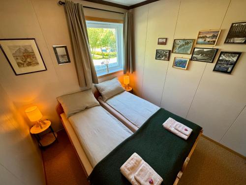 a small bedroom with a bed and a window at Lofoten Light - Private Rooms with Shared Facilities in Gravdal