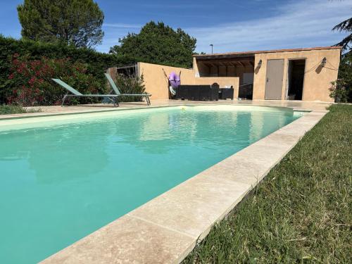 a large blue swimming pool in front of a house at Chicken roulotte des 3 cèdres in Cavaillon