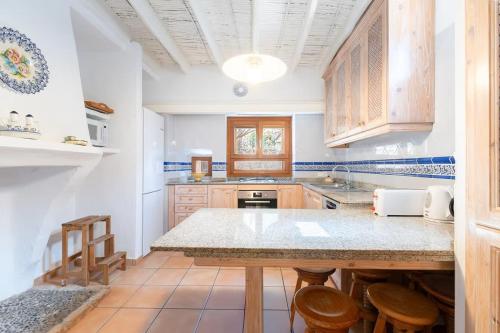 a kitchen with wooden cabinets and a counter top at Casa Es Putxet in Cala Ratjada