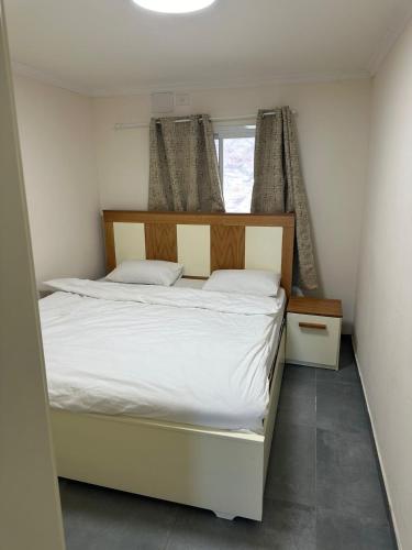 a small bedroom with a bed and a window at carmel cabins suite 7 in Yājur