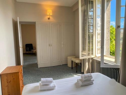 a room with two white towels on top of a bed at Logis Hôtel Du Château - Combourg, Proche Saint-Malo in Combourg