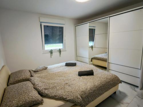 a bedroom with a large bed and a mirror at Apartma Alpine Gateway in Komenda
