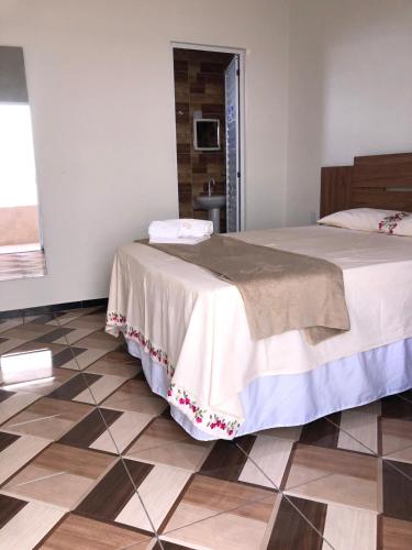 a bedroom with a bed and a tiled floor at Pousada Garrida in Itarema