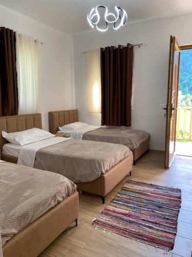 a room with three beds and a rug at Guesthouse Natyra Theth in Theth