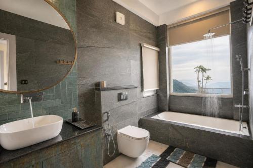 a bathroom with a tub and a toilet and a sink at Anuttara Retreat in Narendranagar