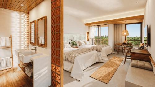 a bedroom with a bed and a sink and a bathroom at Beach Park Resort - Ohana in Aquiraz