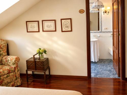 a living room with a couch and a chair at Holibai As Landras Piscina y vistas al Miño, Tomiño in Tomiño