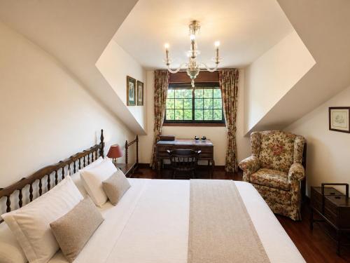 a bedroom with a bed and a chair and a desk at Holibai As Landras Piscina y vistas al Miño, Tomiño in Tomiño