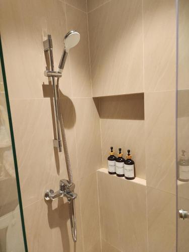 a shower with three bottles of essential oils on a shelf at Resort Living 1BR Corner Apartment with Balcony in Maribago