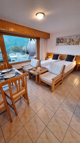 a living room with a couch and a table at Centre Thermal - Studio SUD avec grande terrasse in Ovronnaz