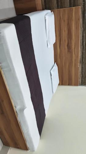 a white bed with a black blanket in a box at Hotel Kanhaiya Inn in Haridwār