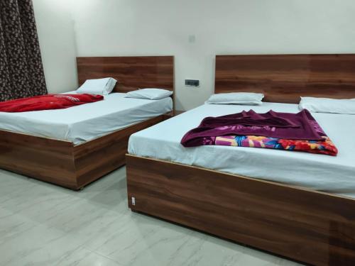 two beds sitting next to each other in a bedroom at Hotel Kanhaiya Inn in Haridwār
