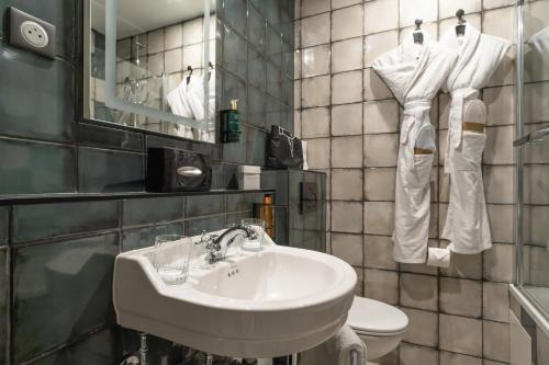 a bathroom with a white sink and a toilet at ELSA, Hôtel Paris by Collection Vesper in Paris