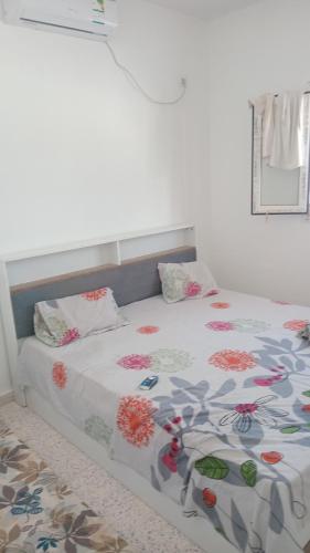 a bedroom with a bed with a floral bedspread at Najib in Djerba