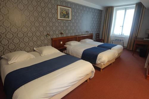 a hotel room with three beds and a window at Cit'Hotel Avallon Vauban in Avallon
