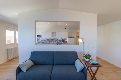 a living room with a blue couch and a mirror at Casa Bortolo in Garda