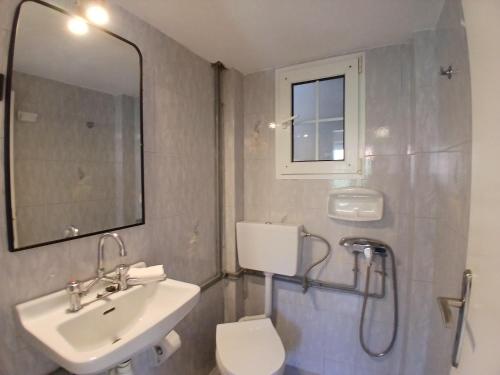 a bathroom with a sink and a toilet and a mirror at Sandra's Nest Gaios Paxos in Gaios