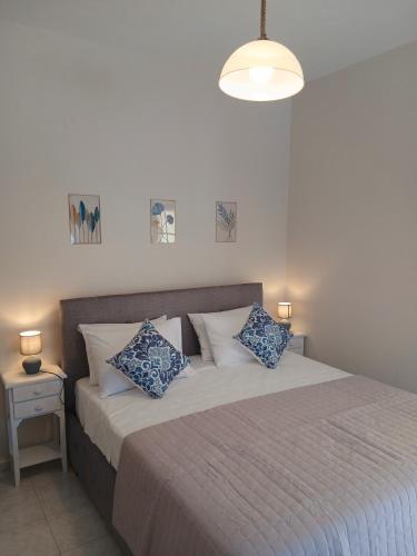 a bedroom with a bed with blue and white pillows at Sandra's Nest Gaios Paxos in Gaios
