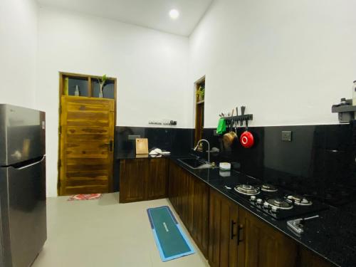 a kitchen with a stove and a refrigerator at ZEN House Arugambay in Arugam Bay