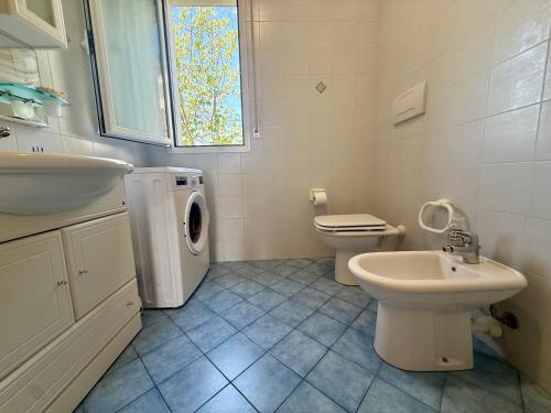 a white bathroom with a sink and a washing machine at Ulivo Liguria With pool in Gazzelli