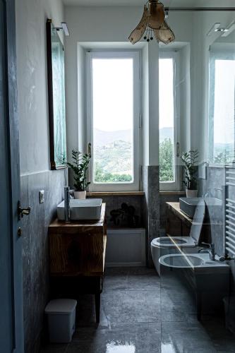 a bathroom with two sinks and a toilet and a window at laperladelfarfa in Castelnuovo di Farfa