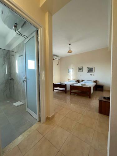a large bathroom with a shower and a bedroom at Marku Palace in Ksamil