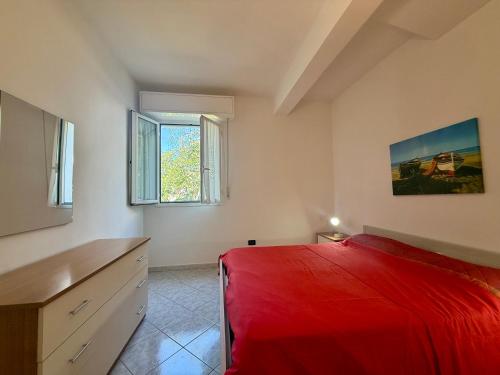 a bedroom with a red bed and two windows at Ulivo Liguria With pool in Gazzelli