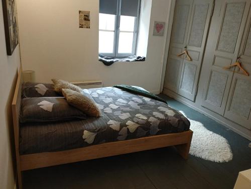 a bedroom with a bed with a comforter and a window at B&B Colvestre in Tréguier