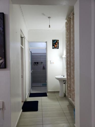 a bathroom with a walk in shower and a sink at SPACIOUS VIP 1 BEDROOM with ROOFTOP SWIMMING POOL AVAILABLE in Mtwapa