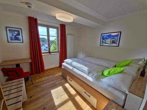 ein Schlafzimmer mit Bett, Schreibtisch und Fenster in der Unterkunft Hotel im Sud in Eggenfelden