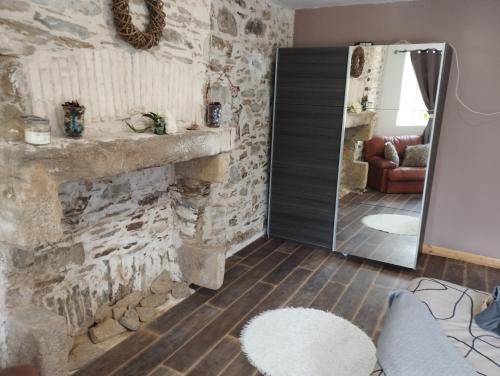 a living room with a stone fireplace and a mirror at B&B Colvestre in Tréguier