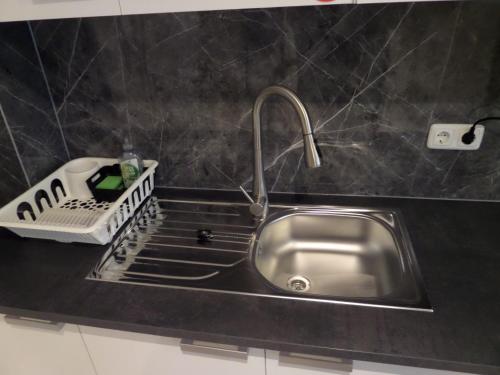 a kitchen sink with a faucet on a counter at Main Boardinghouse in Erlenbach am Main