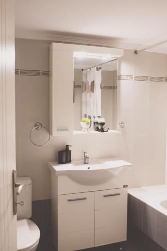 a white bathroom with a sink and a toilet at Iasonas Apartment 2 in Nafplio