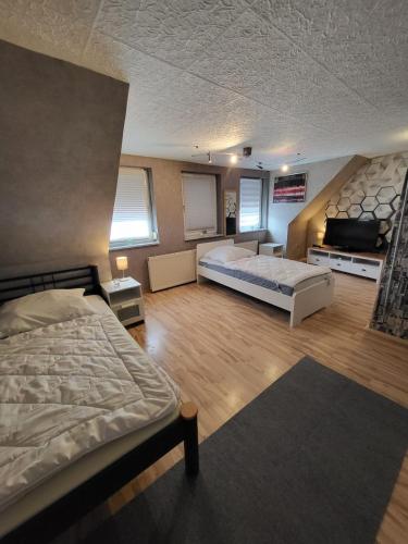 a bedroom with two beds and a flat screen tv at Worker's Home by Nina in Herzberg am Harz