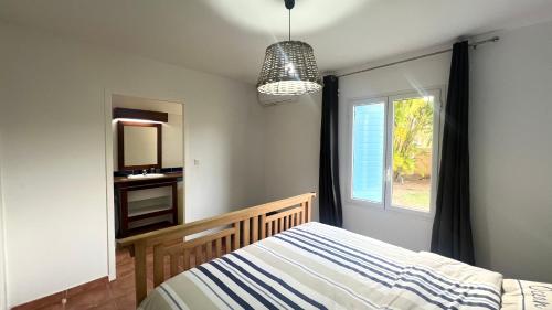a bedroom with a bed and a window at Marisol les pieds dans l eau in Le Gosier