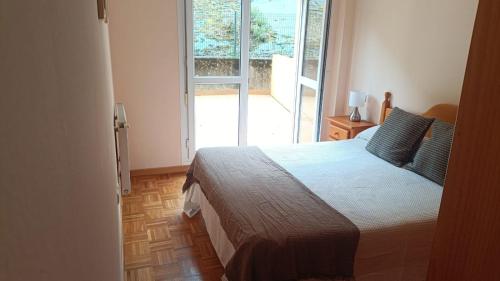a bedroom with a bed and a large window at Atalaya 5 - VUT5463AS in Ribadesella