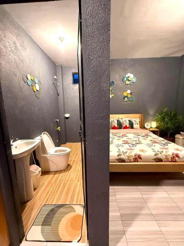 a bedroom with a bed and a toilet and a sink at Shanti's Inn in General Luna
