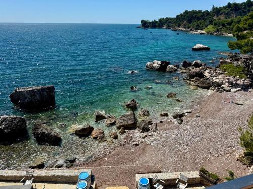 a beach with rocks in the water on a sunny day at Beachfront Luxury Villa - Bar in Bar