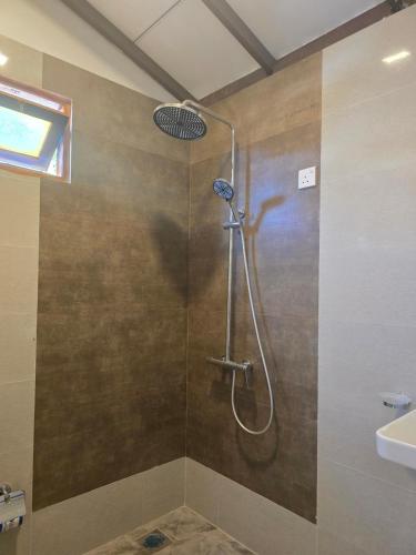 a shower in a bathroom with a glass door at Beach 365 in Nilaveli