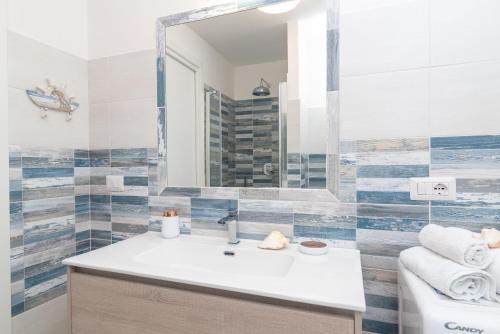 a bathroom with a sink and a mirror at Bilocale nuovo Budoni centro in Budoni